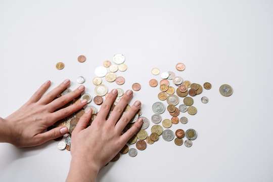 Photo de deux mains avec des pièces de monnaie, évoquant l'épargne investit dans un placement bancaire LEP (Livret d'Epargne Populaire)