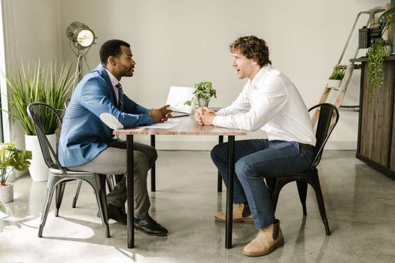 Photo d'un agent général d'assurance avec son client. Appartenant à une profession libérale rattachée à la caisse vieillesse de la CAVAMAC.