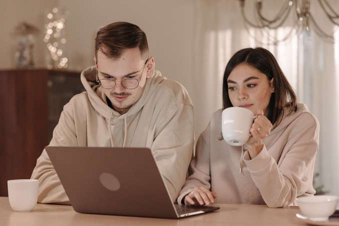 Photo d'un jeune couple qui rédige sa clause bénéficiaire, sur leur contrat de placement financier assurance-vie. Chacun d'entre-eux désigne le conjoint survivant comme bénéficiaire du contrat.