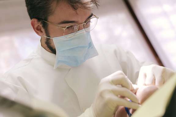 Photo d'un chirurgien-dentiste libéral au cabinet, rattaché à la caisse vieillesse de la CARCDSF.