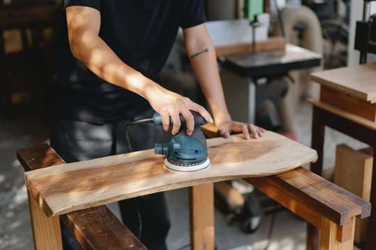 Photo d'un artisan qui travaille dans un atelier. Il a souscrit en cas d'arrêt de travail, un contrat de prévoyance TNS avec un délai de franchise de courte durée.