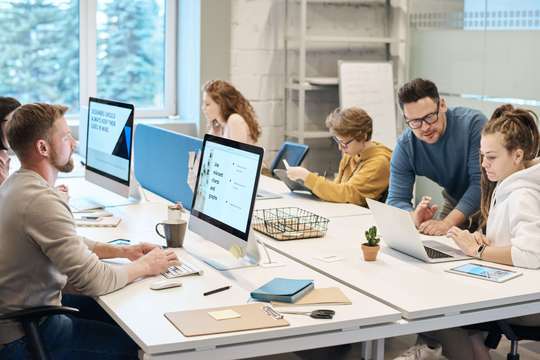 Photo de salariés dans une salle de travail. Ils dépendent tous de la même convention collective au sein de leur entreprise.