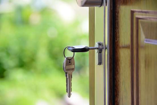 Photo d'une clé sur une porte. Ce sont des emprunteurs qui ont sosucrit un prêt relais pour acheter leur maison.