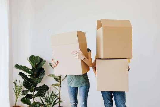 Photo d'un couple qui se cache derrière des cartons. Ils viennent de vendre leur appartement sans aucune plus-value immobilière !