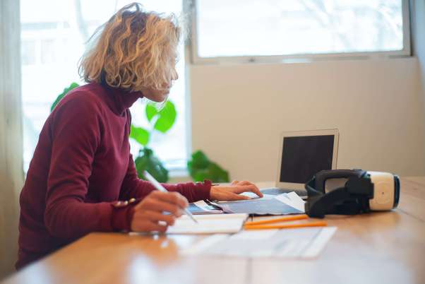 Photo d'une assurée en prévoyance, qui consulte sur son pc portable son contrat assurance prévoyance IPT (Invalidité Permanente Totale).