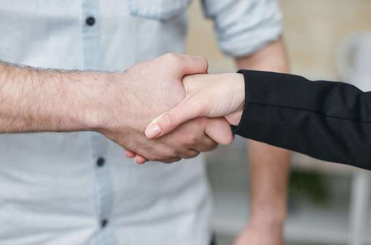 Photo de deux personnes qui se serrent la main. Pour définir le contrat mutuelle responsable et solidaire.
