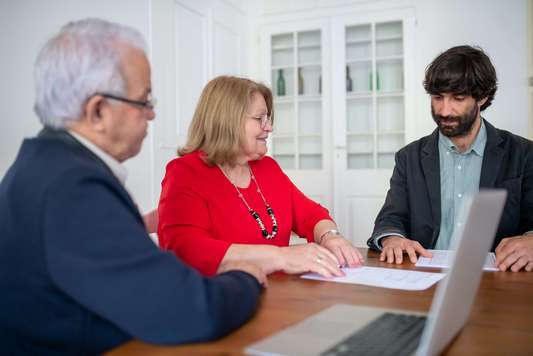 Photo d'un couple avec leur courtier en assurances. Les clients résilient leur assurance mutuelle santé dans le cadre de la Résiliation Infra Annuelle (RIA)