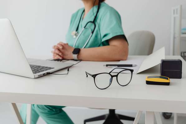 Photo d'un médecin dans son cabinet. Il est signataire de l'OPTAM (L'Option Pratique Tarifaire Maîtrisée).