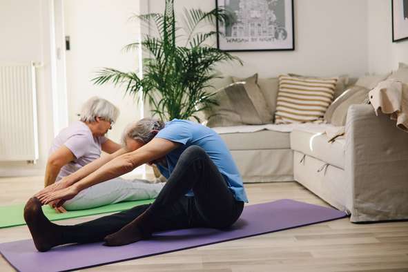 Photo d'un couple de retraités mariés qui font de la gym dans leur maison. En cas de décès de l'un d'eux, le survivant peut percevoir une pension de réversion du régime de base.