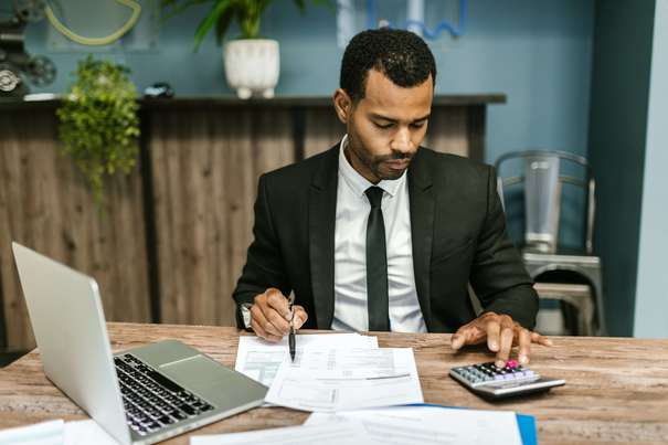 Photo d'un conseiller en assurance-vie, qui calcule la fiscalité d'un client, assujetti à la flat Tax sur son contrat d'épargne.