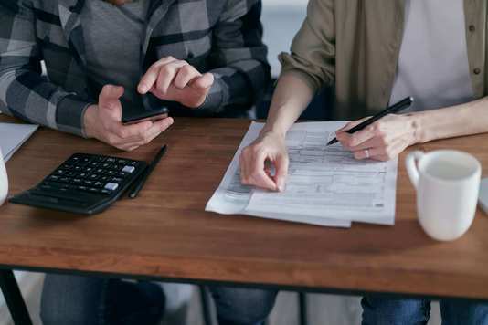 Photo d'un couple d'indépendant qui calcule leur plafond madelin tns