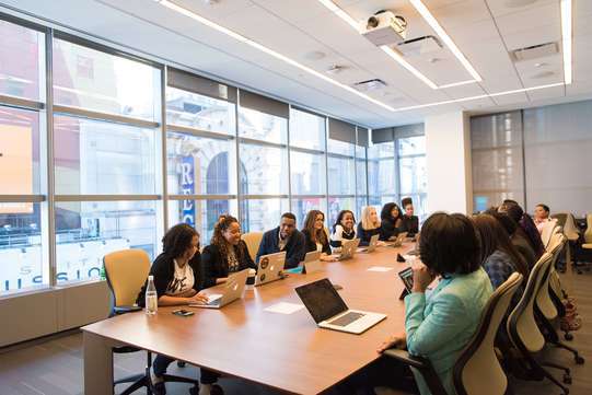 Photo de salariés dans une salle de réunion. Ils discutent de la prévoyance cadre des salariés.