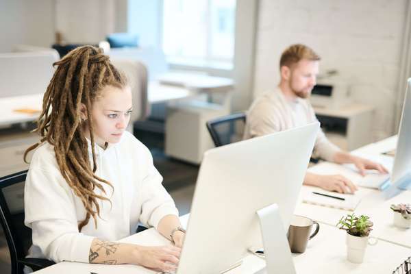 Photo de 2 Courtiers en prévoyance TNS devant leurs ordinateurs. Ils consultent le contrat prévoyance invalidité de leurs clients en ligne.