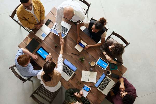 Photo d'un groupe d'associés d'une société civile immobilière (SCI). Ils sont réunis autour d'une table de réunion.