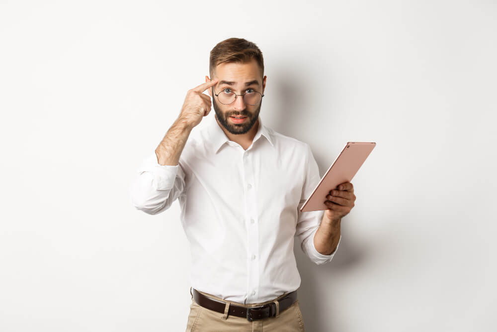 Un actif réfléchi utilise sa tablette pour s'informer sur le fonctionnement du régime de retraite de base.