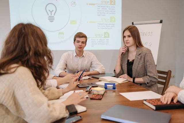 Une équipe en réunion de travail échangeant autour des exigences d'une prévoyance d'entreprise obligatoire.