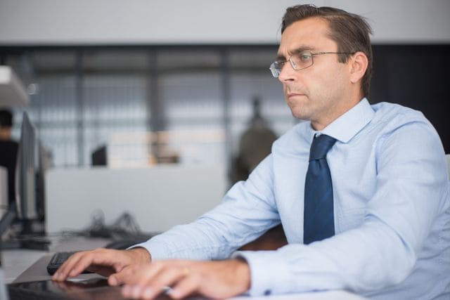 Simulation de l'IFI (Impôt sur la Fortune Immobilière) réalisée par un conseiller en gestion de patrimoine sur un clavier d'ordinateur.