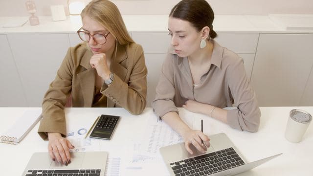 Conseillères en gestion de patrimoine analysant les barèmes de l'IFI (Impôt sur la Fortune Immobilière) avec une cliente.